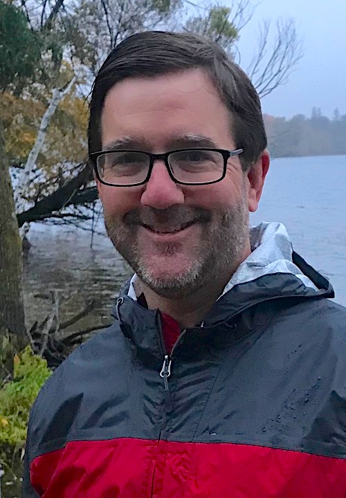 Pastor Eric with a lake in the background